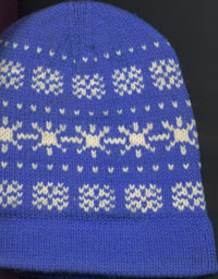 Blue hat with white patterns with cuff turned down